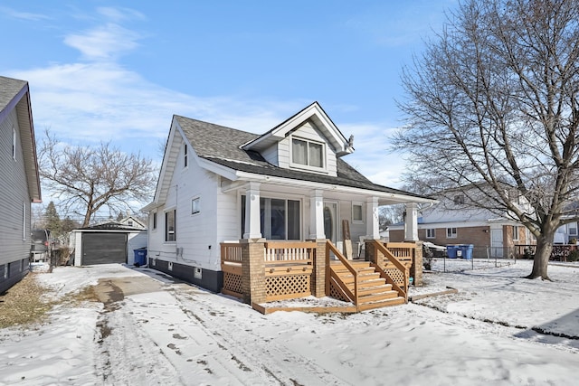 bungalow-style home with a garage, an outdoor structure, and covered porch