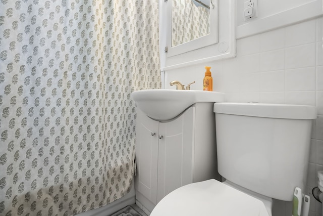 bathroom with a shower with curtain, vanity, toilet, and tile walls