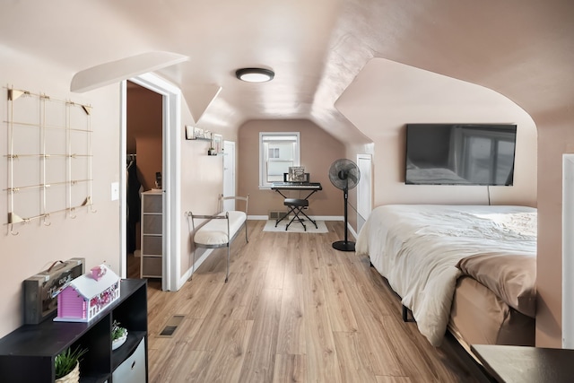 bedroom with lofted ceiling and light hardwood / wood-style flooring