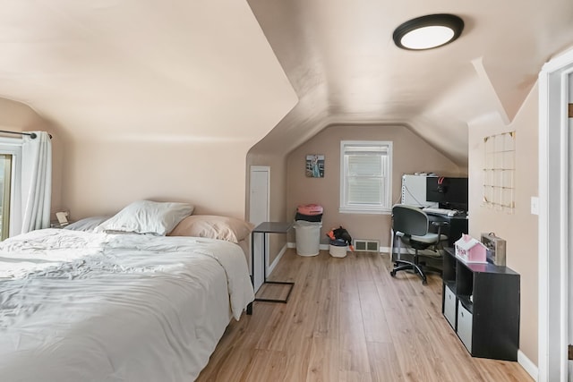 bedroom featuring light hardwood / wood-style flooring and vaulted ceiling