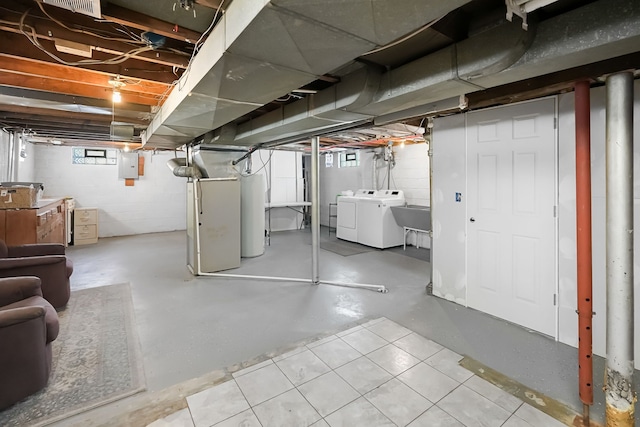 basement with sink, gas water heater, electric panel, and washer and dryer