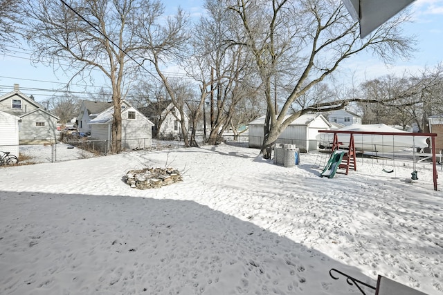 yard layered in snow featuring a playground