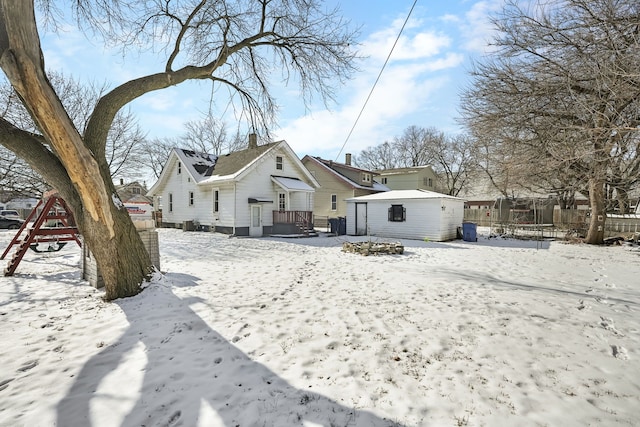 snow covered property with an outdoor structure