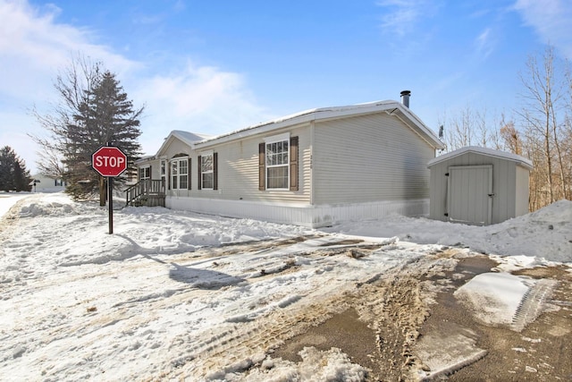 view of snowy exterior with a storage unit