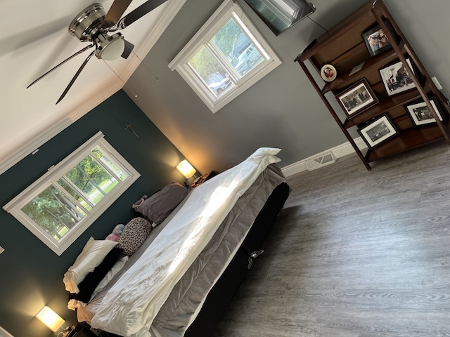 unfurnished bedroom featuring ceiling fan, wood-type flooring, and a skylight