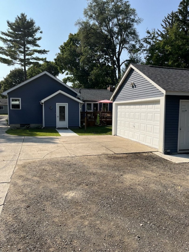 exterior space featuring a garage and an outbuilding