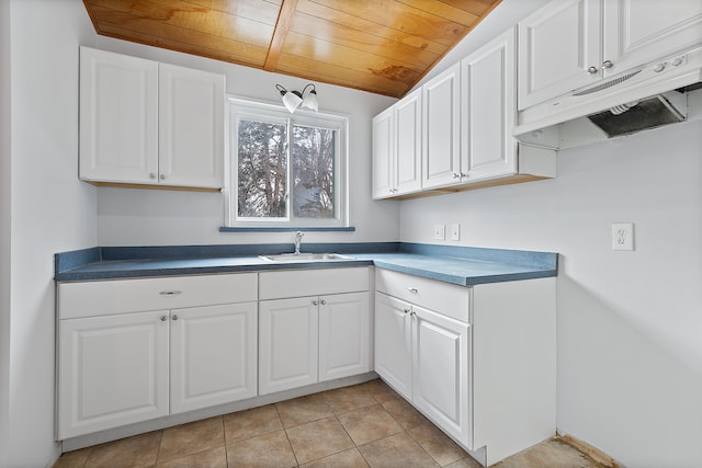 kitchen featuring lofted ceiling, sink, white cabinets, light tile patterned floors, and wooden ceiling