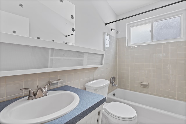 full bathroom featuring tile walls, decorative backsplash, tiled shower / bath combo, vanity, and toilet