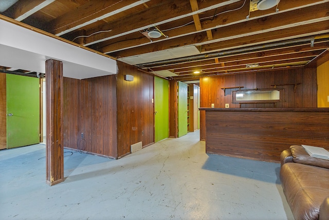 basement featuring wooden walls