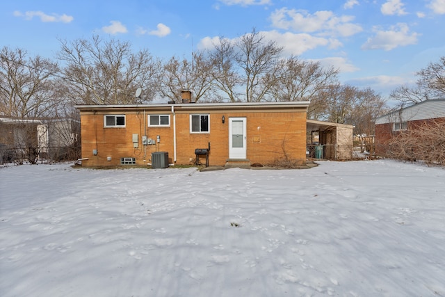 snow covered rear of property featuring cooling unit