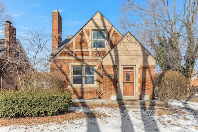 view of front facade featuring brick siding and a chimney