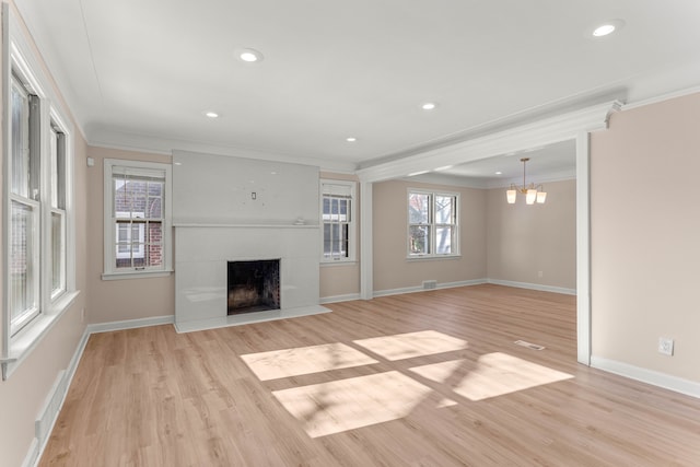 unfurnished living room featuring crown molding, baseboards, a fireplace with flush hearth, an inviting chandelier, and light wood-style floors