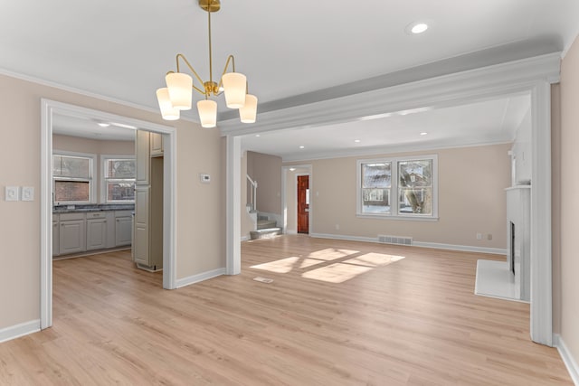 unfurnished dining area featuring crown molding, a chandelier, and light hardwood / wood-style flooring