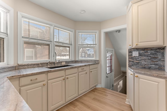 kitchen featuring sink, light hardwood / wood-style flooring, and decorative backsplash