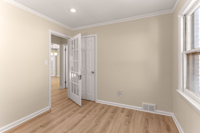 spare room with crown molding and light wood-type flooring