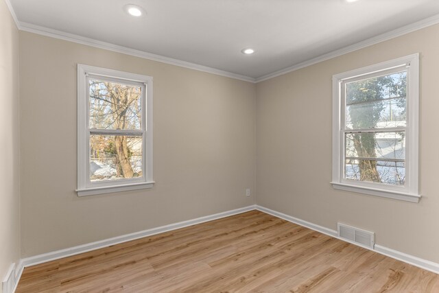 unfurnished room featuring ornamental molding, a healthy amount of sunlight, and light hardwood / wood-style flooring