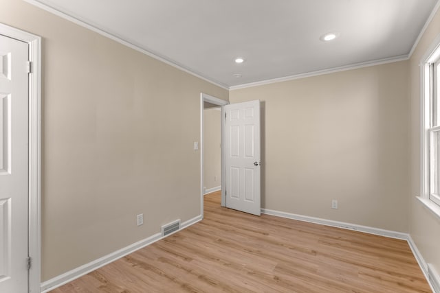 unfurnished bedroom with multiple windows, crown molding, and light wood-type flooring