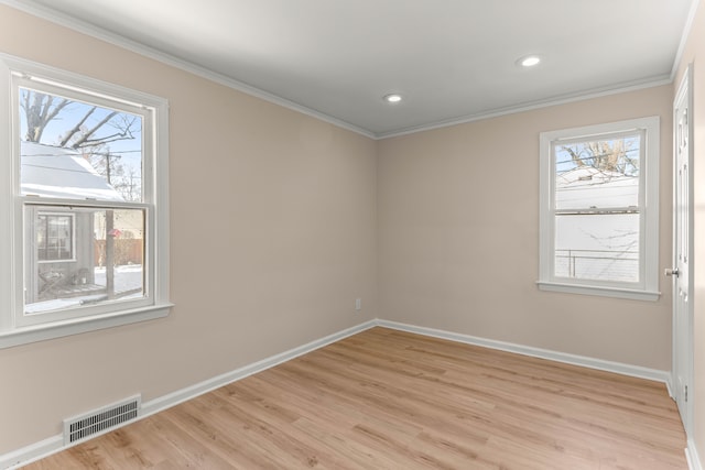 unfurnished room with ornamental molding, a wealth of natural light, and light wood-type flooring