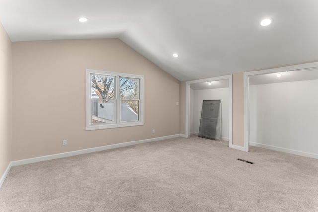 interior space with light colored carpet and lofted ceiling