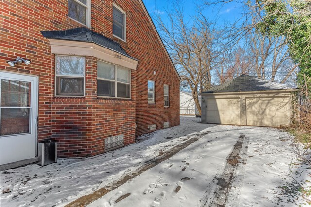 view of snow covered exterior with a garage and an outdoor structure