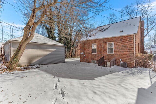 snow covered back of property with central air condition unit