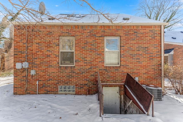 snow covered property featuring central AC unit