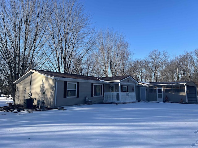 ranch-style house featuring cooling unit, a garage, and a porch