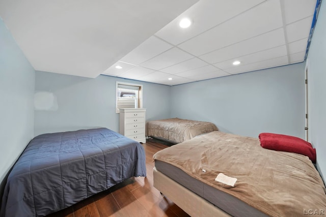 bedroom with hardwood / wood-style flooring and a paneled ceiling