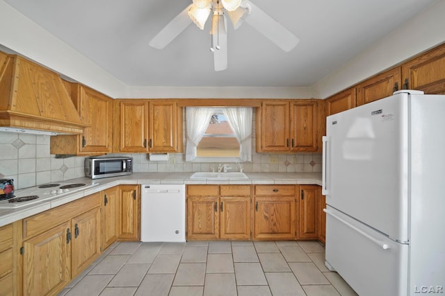 kitchen featuring sink, white appliances, premium range hood, backsplash, and light tile patterned flooring