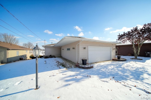 view of snowy exterior featuring a garage