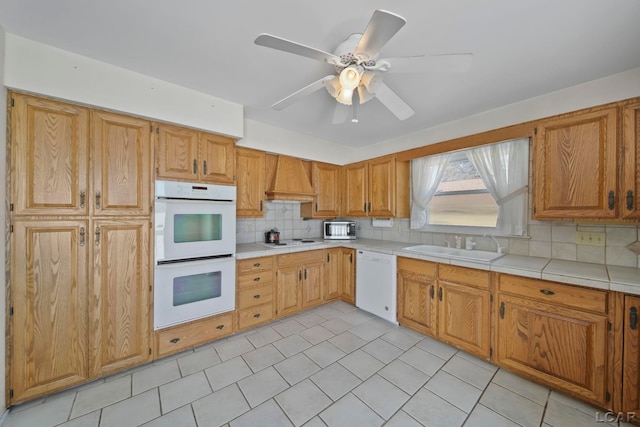 kitchen featuring sink, white appliances, ceiling fan, premium range hood, and tasteful backsplash