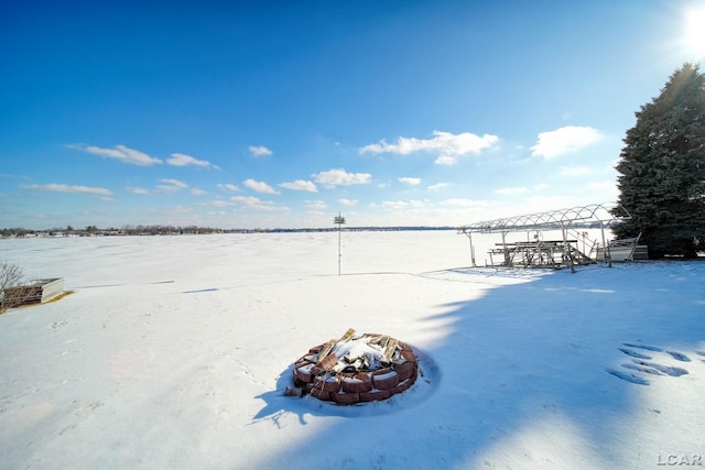 yard layered in snow featuring an outdoor fire pit