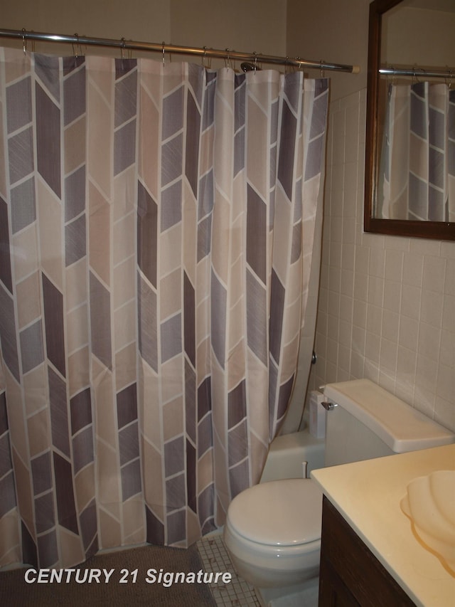 bathroom with vanity, tile walls, tile patterned floors, and toilet