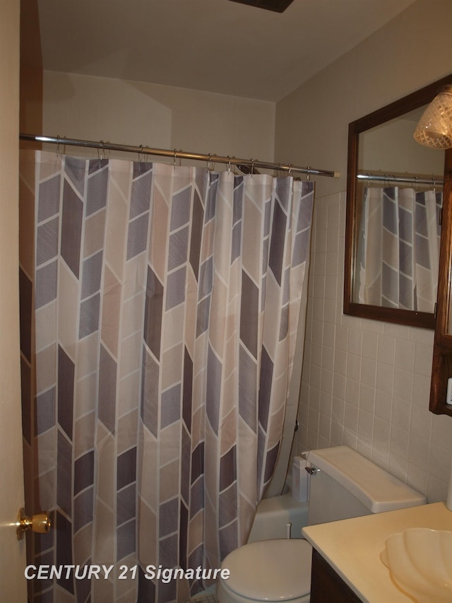 full bathroom with shower / bathtub combination with curtain, vanity, toilet, and tile walls