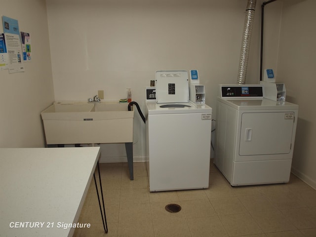 clothes washing area featuring sink and washing machine and clothes dryer