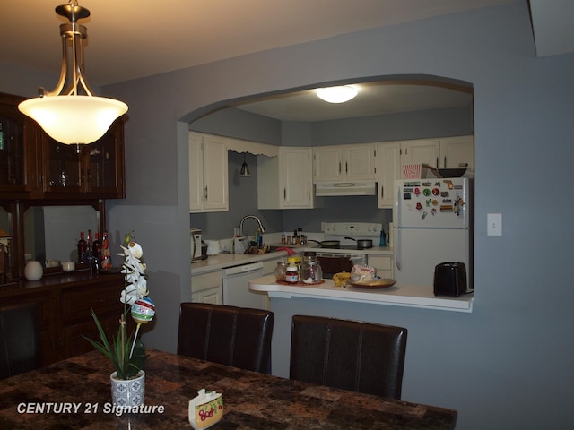 kitchen featuring white cabinetry, sink, pendant lighting, and white appliances