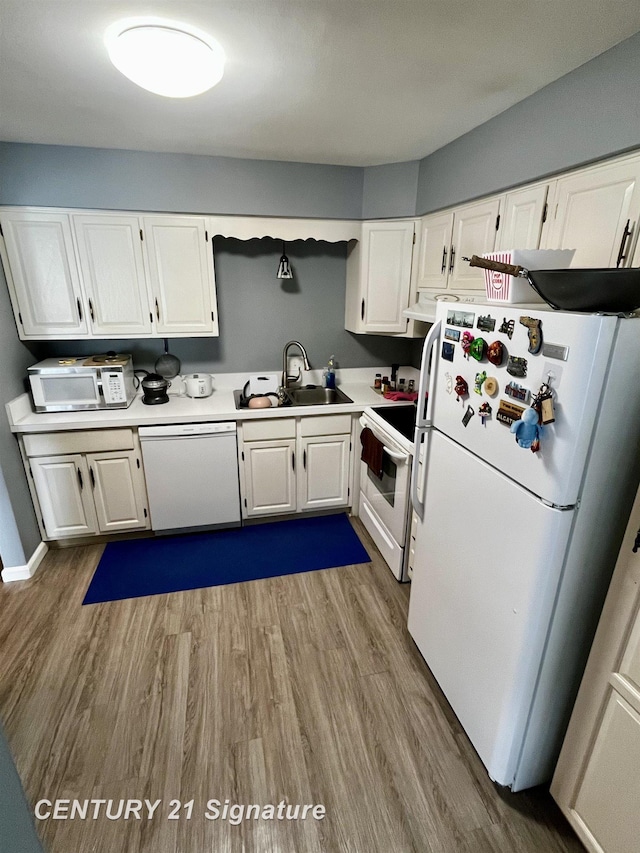 kitchen with white cabinetry, sink, dark wood-type flooring, and white appliances