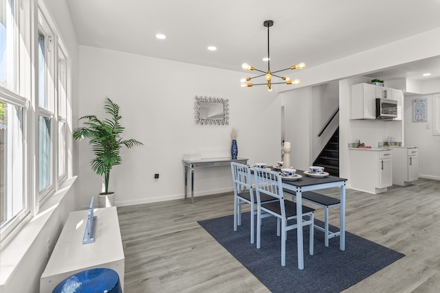 dining area with an inviting chandelier and light hardwood / wood-style flooring