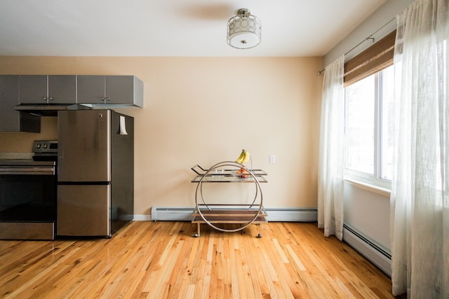 kitchen featuring baseboard heating, appliances with stainless steel finishes, light hardwood / wood-style flooring, and gray cabinetry