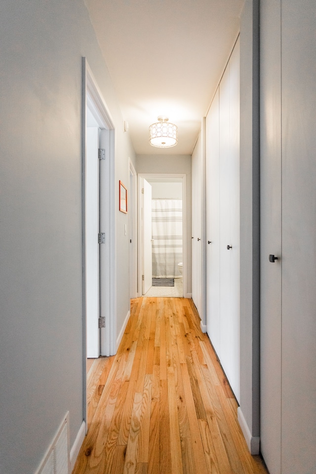 corridor with light hardwood / wood-style floors