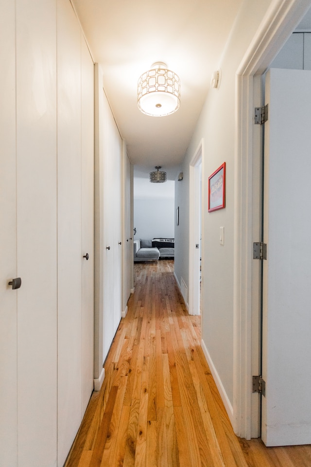 corridor with light hardwood / wood-style floors