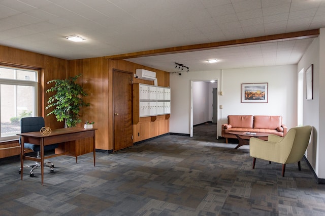 office space with mail boxes, rail lighting, a wall mounted air conditioner, and wood walls