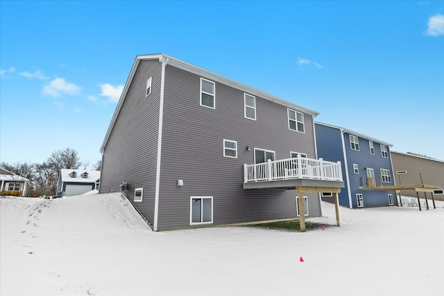 snow covered house with a wooden deck