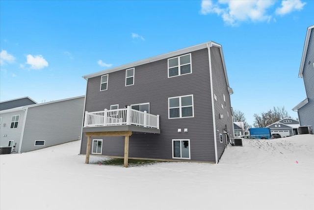 snow covered rear of property featuring central air condition unit and a deck