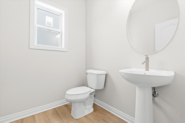 bathroom featuring wood-type flooring and toilet