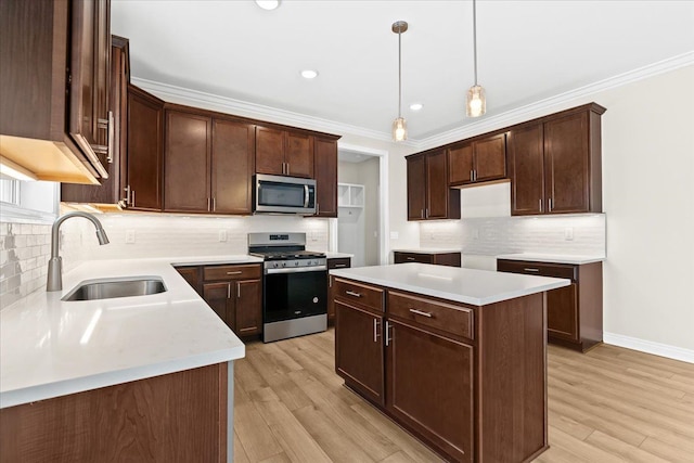 kitchen featuring sink, appliances with stainless steel finishes, hanging light fixtures, ornamental molding, and a kitchen island