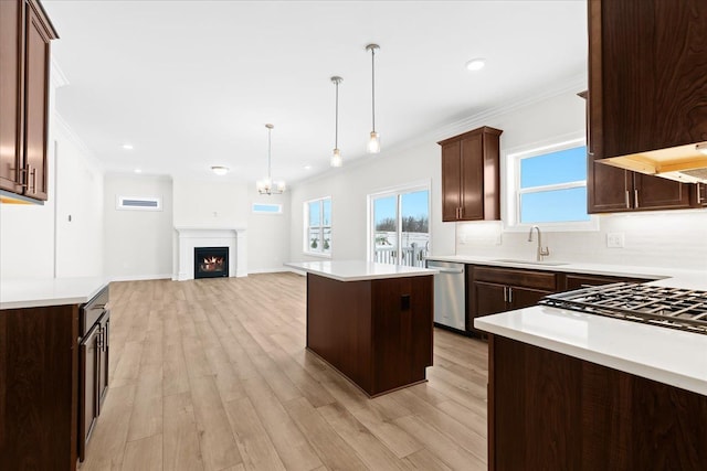 kitchen with sink, crown molding, a center island, hanging light fixtures, and dishwasher