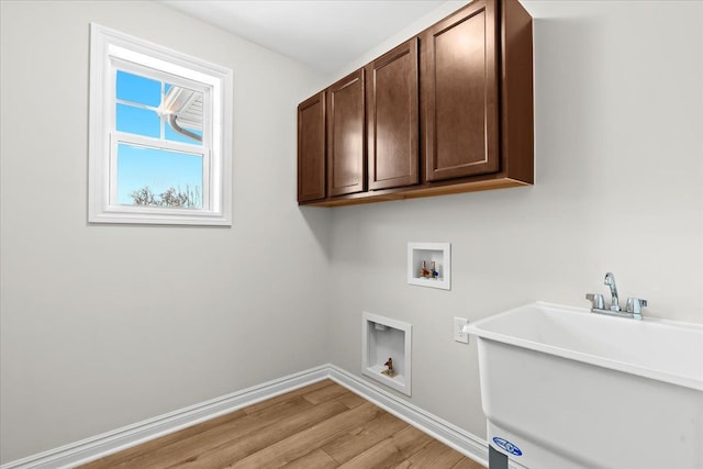 laundry area with cabinets, hookup for a washing machine, sink, and light hardwood / wood-style floors