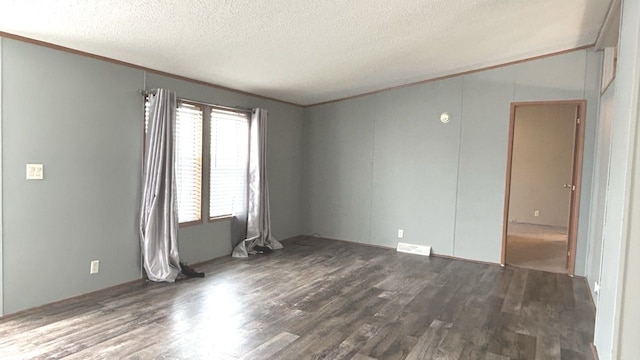 unfurnished room with a textured ceiling, dark wood-type flooring, and ornamental molding