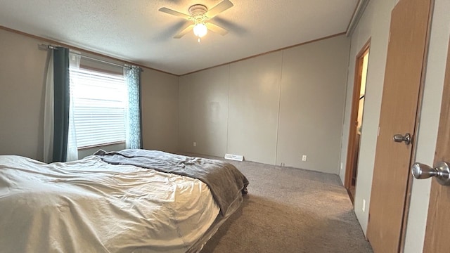 carpeted bedroom with a textured ceiling, ceiling fan, and ornamental molding